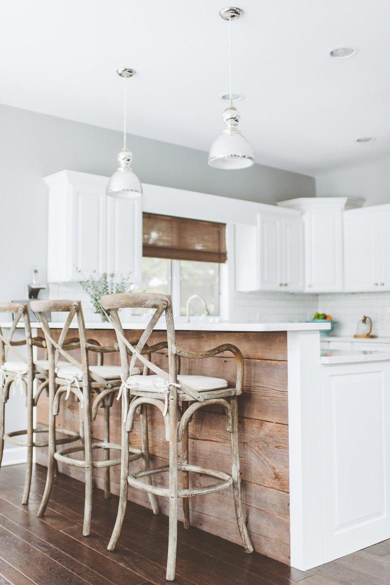 white and reclaimed wood two-tier kitchen island with wood bar stools