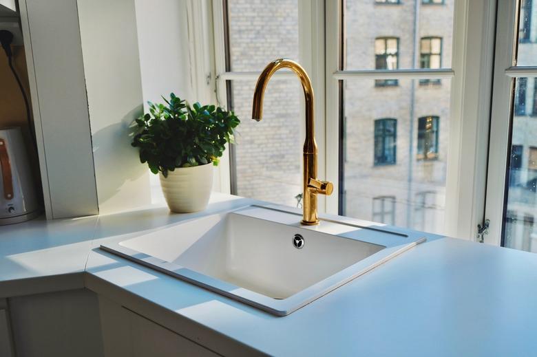 Kitchen Sink And Potted Plant By Window At Home