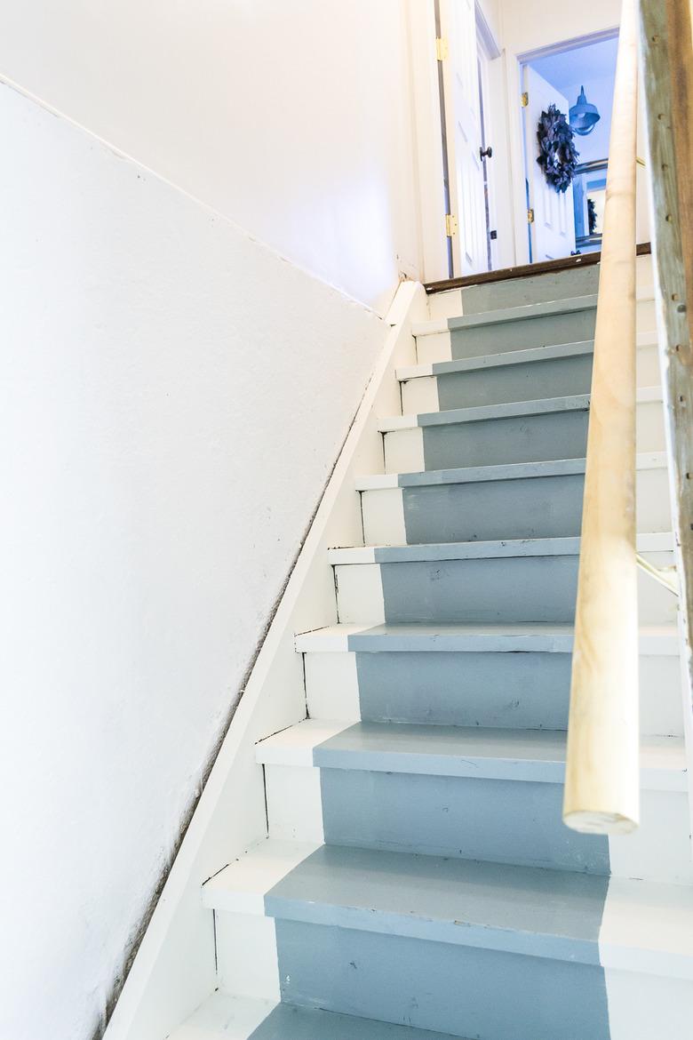 white unfinished basement idea with stairs with painted blue runner