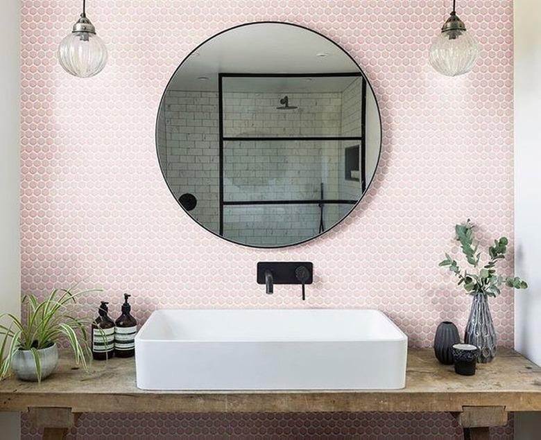 Modern rustic bathroom with white trough sink, pink hectaganol backsplash, black Wall-Mounted Bathroom Faucet, globe lamps, wood vanity.