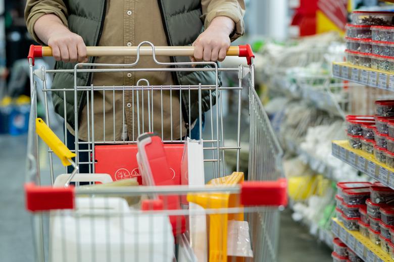 Man in casualwear pushing shopping cart