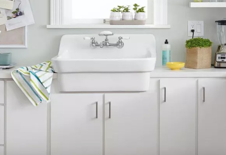 Best kitchen sink materials White cast iron wink, white cabinets, plants, windows.