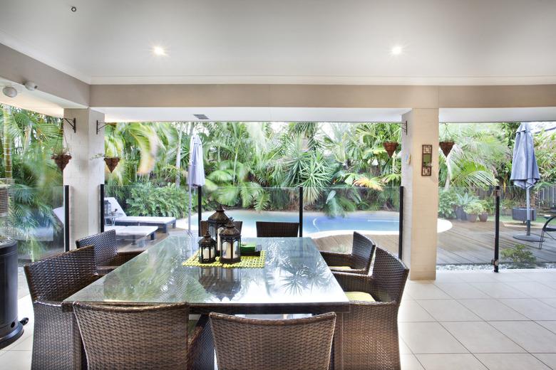 Outdoor dining glass table near swimming pool.