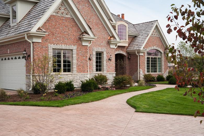 Lovely red brick upscale home with concrete driveway.