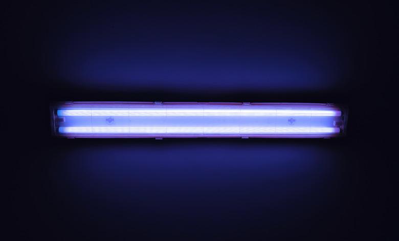 Detail shot of a fluorescent light tube on a wall.