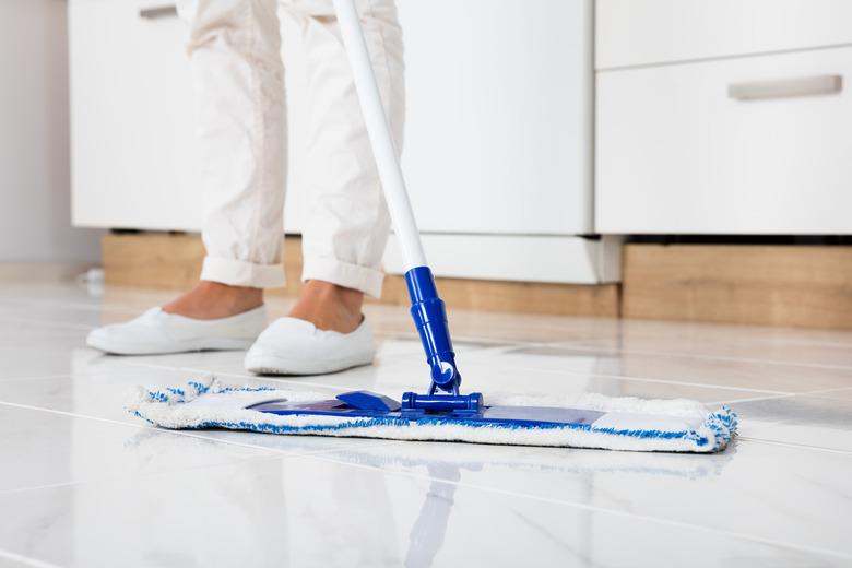 Woman mopping kitchen floor.