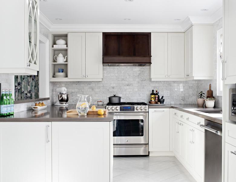 White kitchen with marble white kitchen floor tiles and wooden hood