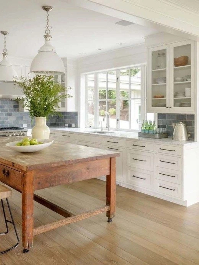 white kitchen with rustic kitchen island  and blue subway tile backsplash