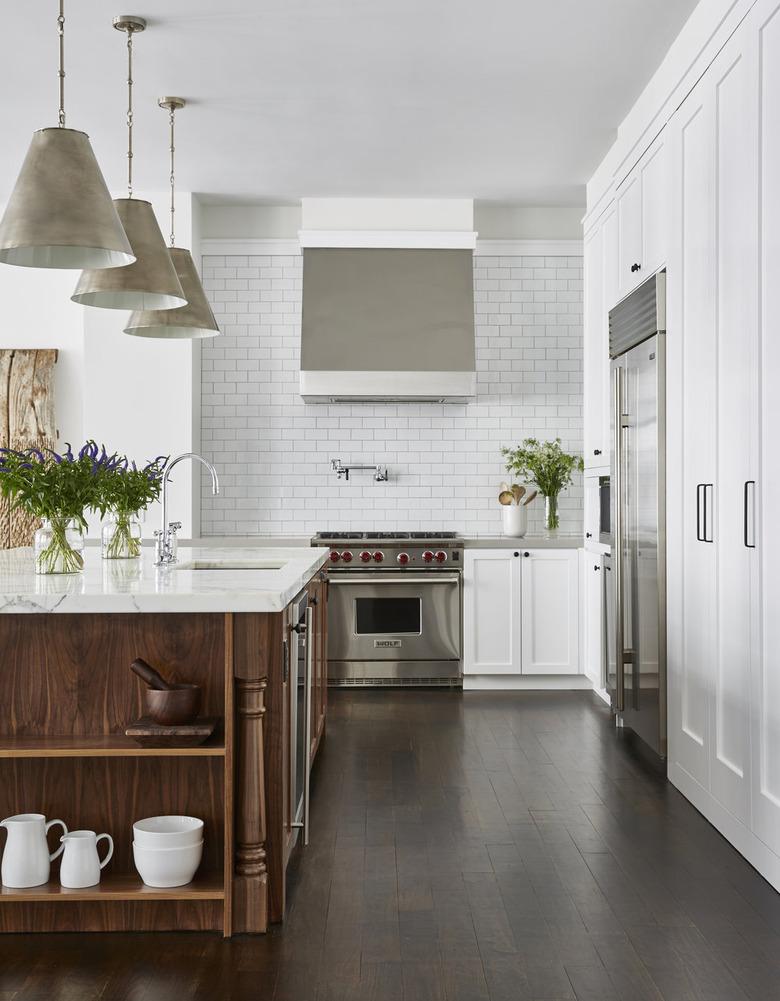 white kitchen with espresso wood island and subway tile