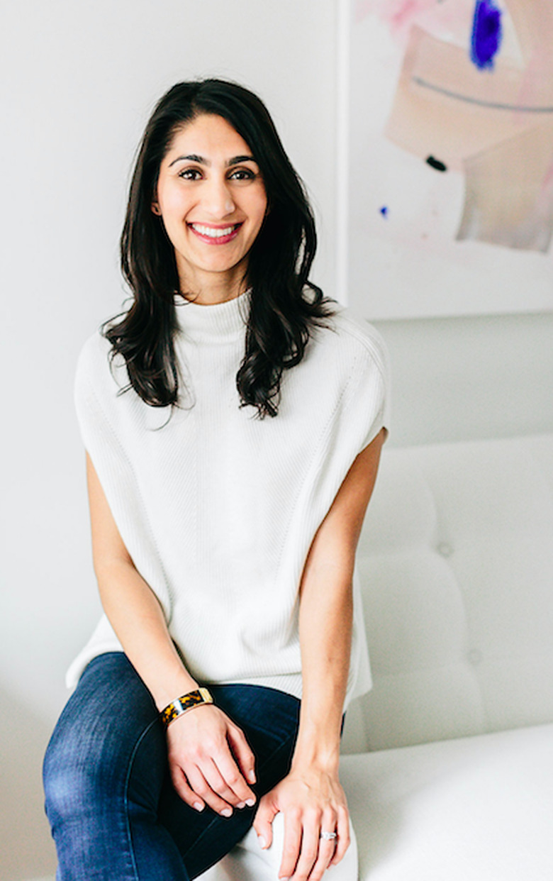 designer nidhi kapur sitting on arm of white couch