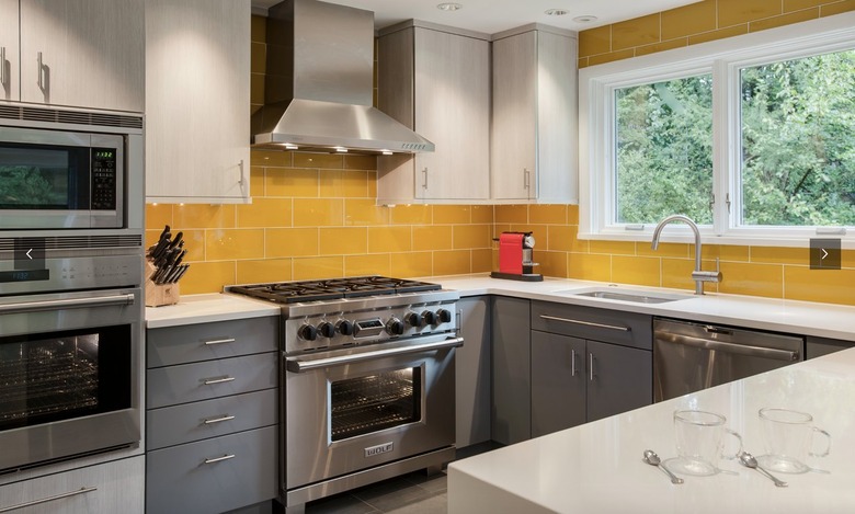 Kitchen with dark grey cabinets and yellow subway tile backsplash.