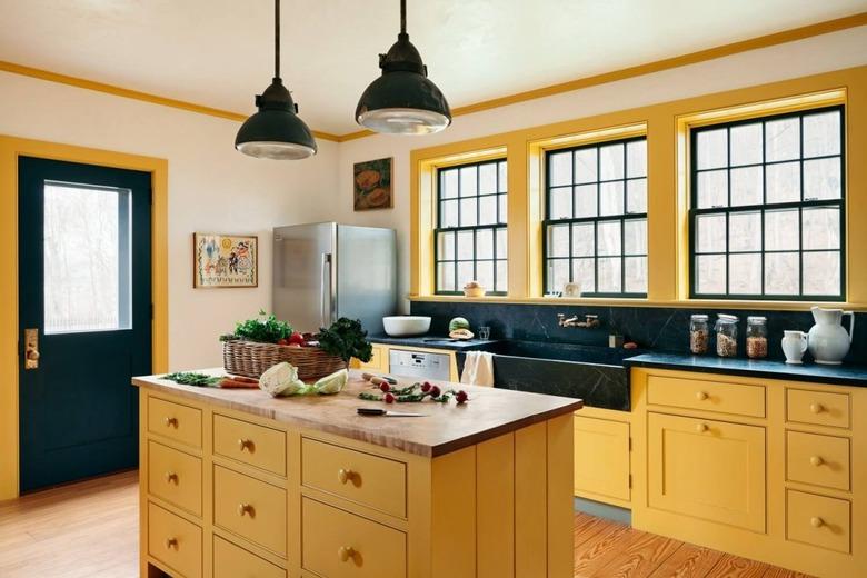 Yellow kitchen color idea with black countertops and yellow island