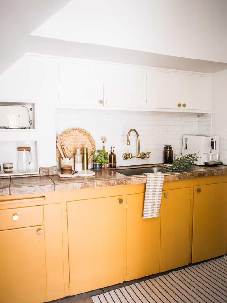 Yellow kitchen color idea with white upper cabinets and gold hardware.