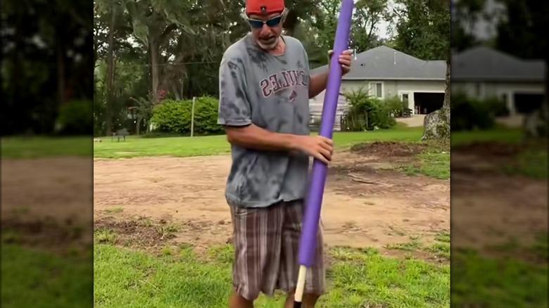 man holding a shovel with a pool noodle grip