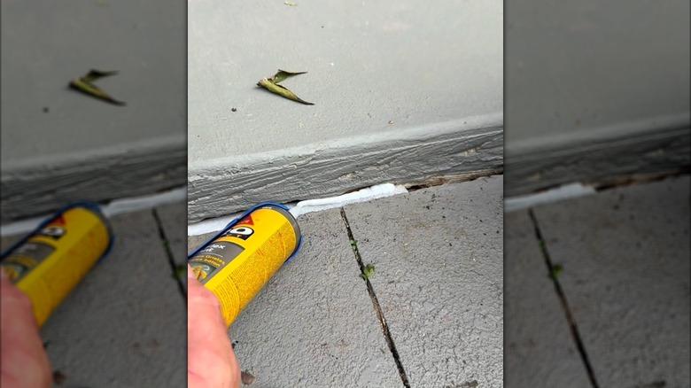 caulking gun applying caulk on a pool noodle in a cement crack