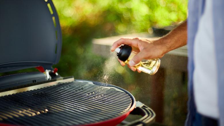 Person spraying grill grate with oil out of a spray bottle