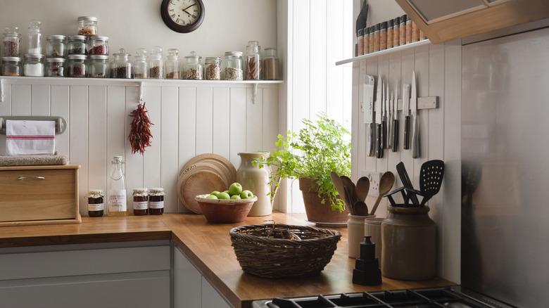 kitchen with white cabinets, wood countertops, vertical shiplap backsplash, and open shelving with clear food jars