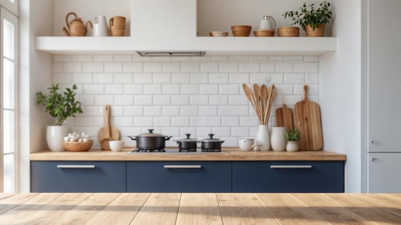 kitchen with navy blue lower cabinets, wood countertops, white subway tile backsplash, and white hood with integrated open shelf above cooktop