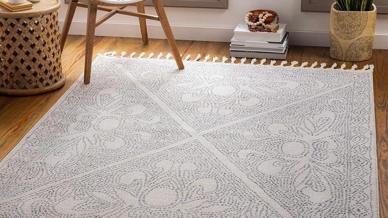 white rug with gray floral pattern