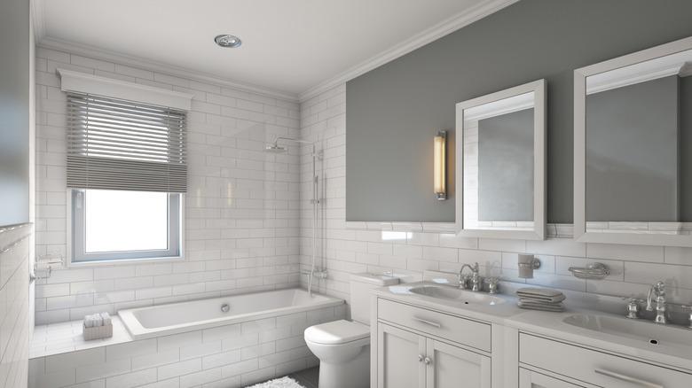 white and gray bathroom with subway tiles, double sink and bathtub