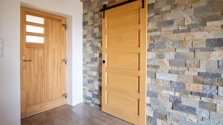 A light wood barn door concealing a closet space
