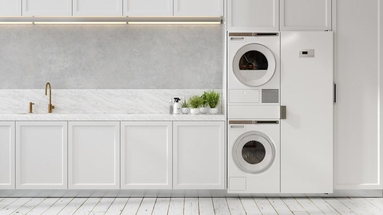 Stacked washer and dryer blending in with white kitchen cabinetry