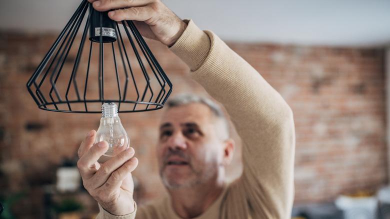 man changing light bulb