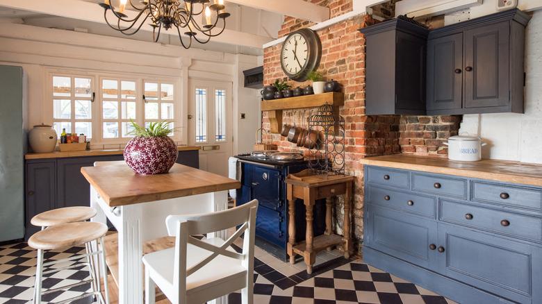 rustic kitchen with dark blue cabinets, wood and brick accents, and rustic chandelier