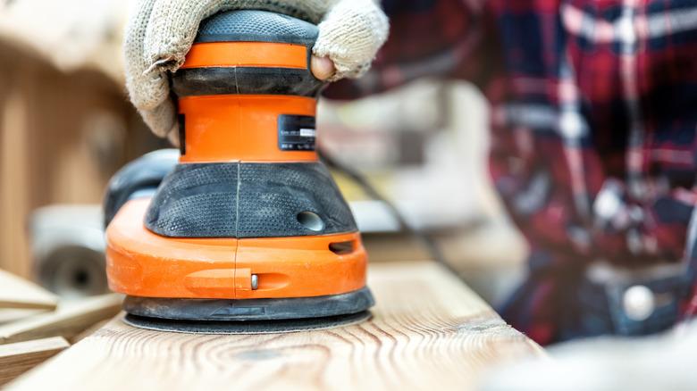 Rotary sander sanding pine