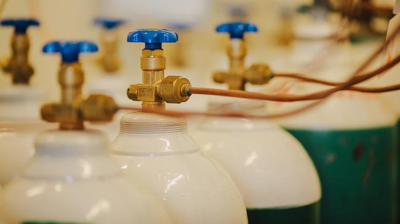 A series of propane tank valves are connected to nozzles.