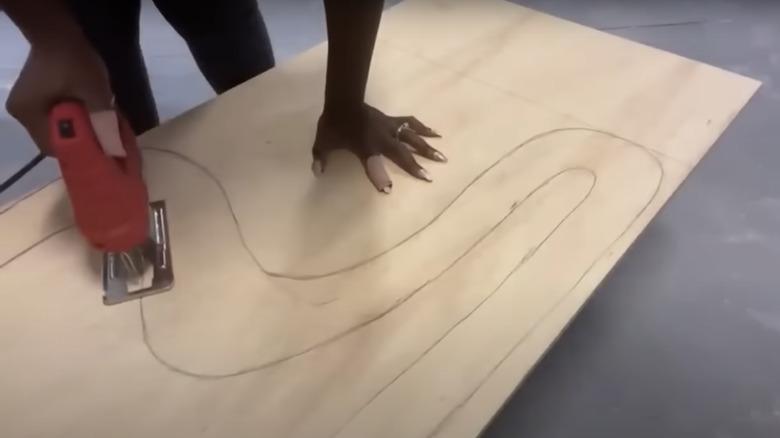 using a jigsaw to cut out a plywood side panel for the chair