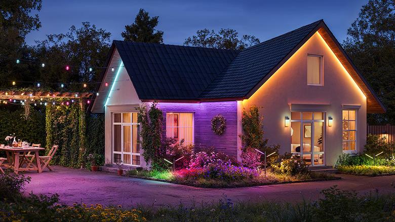 house with colorful Govee garden lights surrounding it to create colorful lighting effects and light pathways