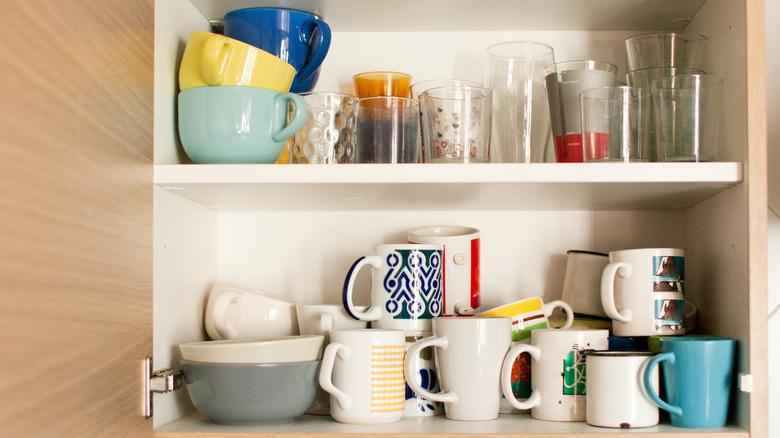 cabinet cluttered with mugs and drinking glasses