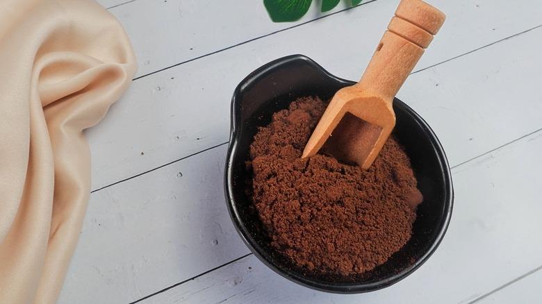 A bowl of coffee grounds with a scooper