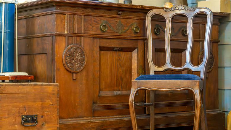 Worn and scratched wooden chair and sideboard