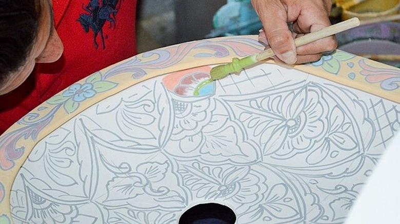 hand painting a Mexican Talavera sink