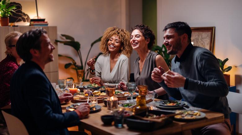 group of people sitting and eating at dining table