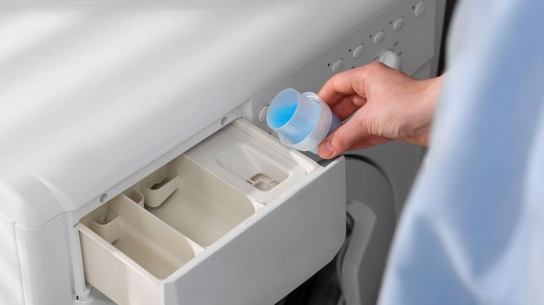 pouring fabric softener into washer