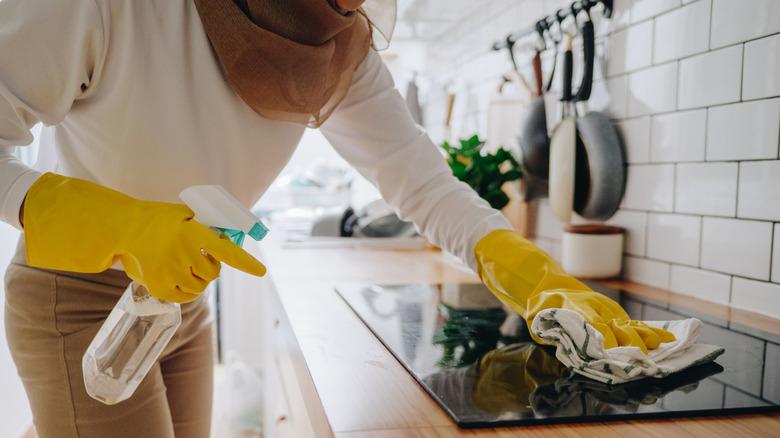 Woman wiping down glass cooktop
