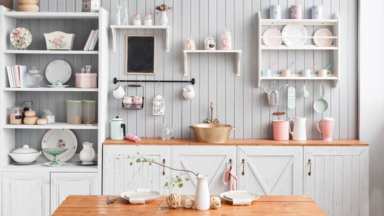 Open kichen with white shelves and light dishes