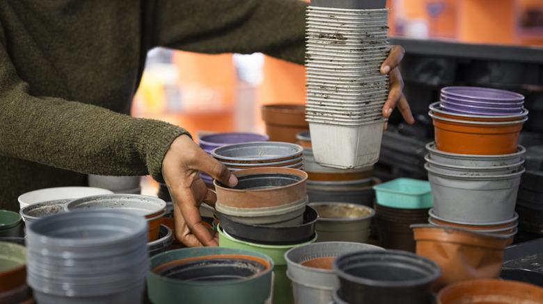 person sorting empty plastic nursery pots