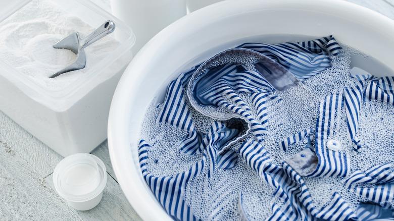 Blue and white striped shirt soaking in white tub