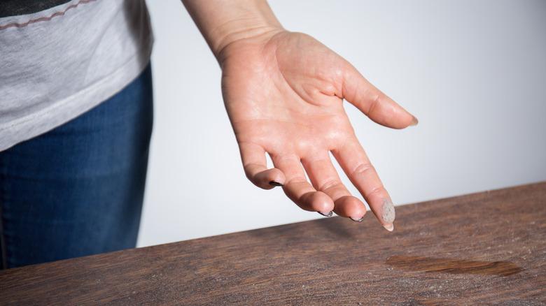 Woman with a dusty finger and table