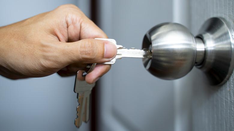 House keys are inserted into a stainless steel doorknob.