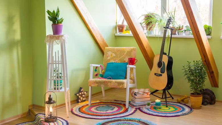 Eclectic reading and music nook featuring lime green walls and lots of indoor plants, a guitar, a candles, and colorful woven rugs.