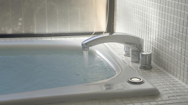 Faucet filling bathtub with water