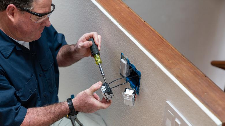 Electrician installing a light switch in a home