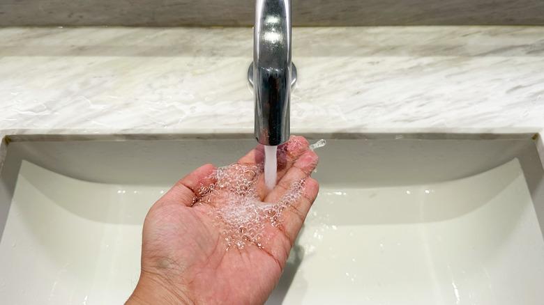 Washing hands with touchless faucet