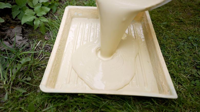 Preparing tray of paint to use on home's exterior