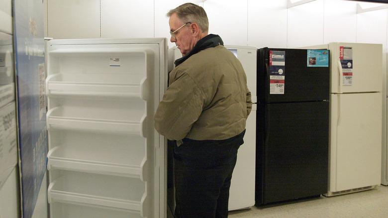 Man examining Kenmor refrigerator